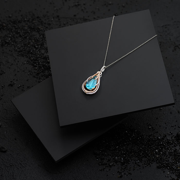 Blue gemstone necklace photographed on black tiles
