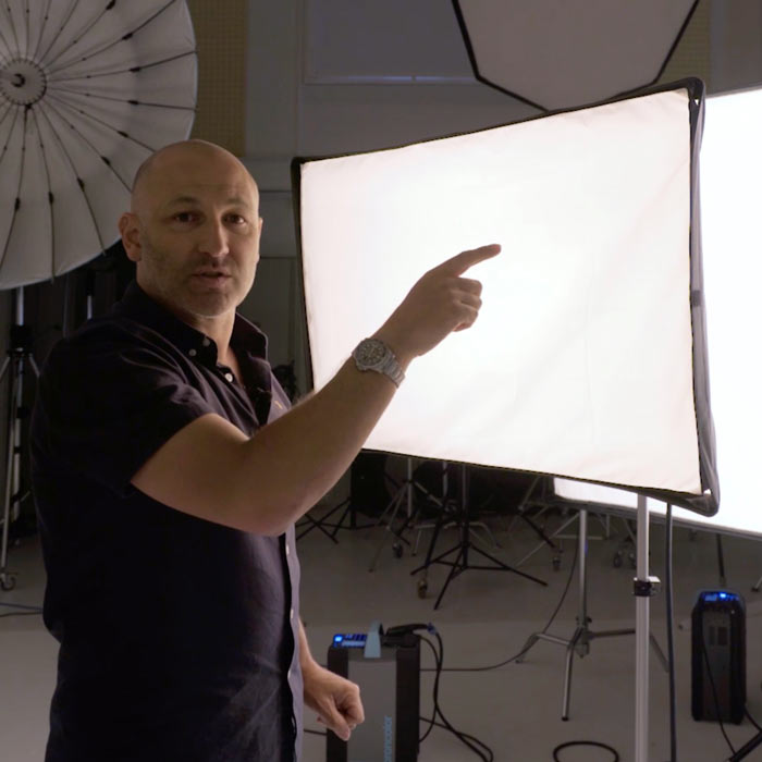 Karl pointing at a large softbox